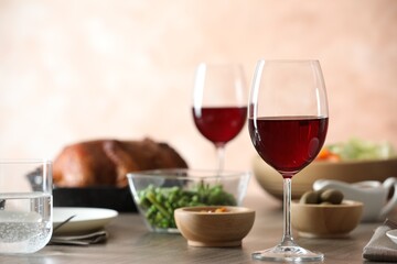 Red wine and delicious dinner served on wooden table