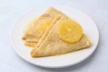 Delicious Crepes Suzette on white tiled table, closeup
