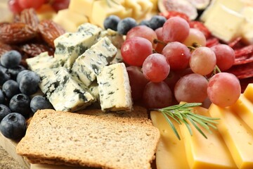 Different types of delicious cheese and other snacks as background, closeup