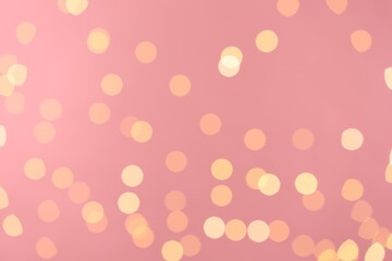 Blurred view of golden lights on pink background. Bokeh effect