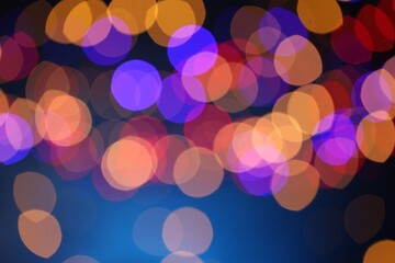 Blurred view of colorful lights on dark blue background, bokeh effect
