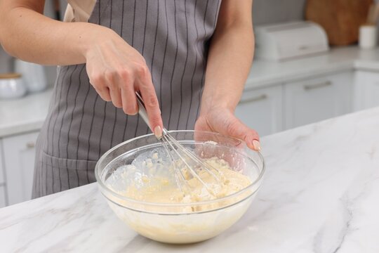 Woman making dough at white marble table indoors, closeup