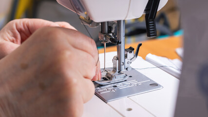 A detailed close up view of a person skillfully using a sewing machine