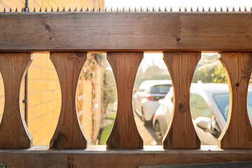 Shallow focus of a newly installed garden gate showing security spikes on the top. A two car driveway with cars can be seen on a crips winters morning in the UK.