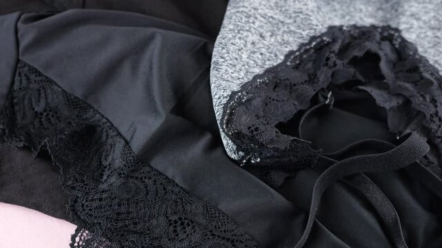 Knitted casual, women's underwear, black panties and gray melange top rotate on display case.