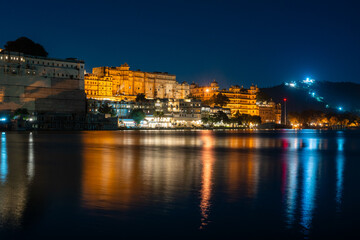 Obraz premium Stadtansicht und Stadtbild vom Stadtpalast am See in Udaipur in Rajasthan Indien bei Nacht 