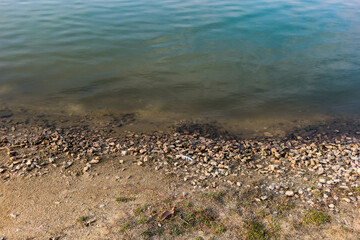 sea shore sand rock beach with clear green water horizontal water