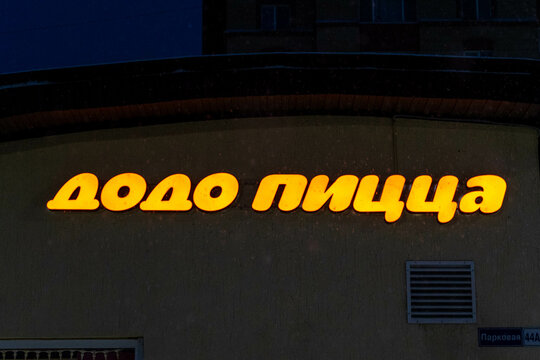 Russia, Sosnovy Bor, December, 31, 2024 -A neon sign showcases a Russian pizza restaurant at night. Dodo pizza