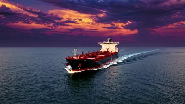 A big LNG tanker ship travelling over the calm ocean during sunset
