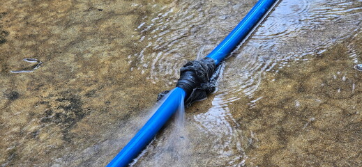 A blue hose with black Scotch tape tied around it because it had leak. The hose is used for...