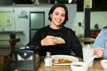 Delighted patron savoring tasty tacos and relishing authentic mexican fare at a lively taqueria