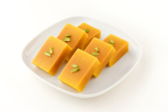 Mysore pak, a traditional, popular, and delicious sweet dish native to the city of Mysore, Karnataka, India, is made from ingredients like gram flour, ghee and sugar, on a ceramic plate.