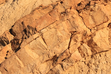 texture of a stone slope illuminated by the sun at sunset