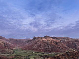 Beautiful aerial drone landscape image of Blea Tarn and Langdale Valley in Lake District during vibrant Autumn sunrise