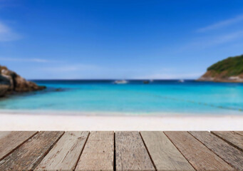 Fototapeta premium Wooden table top on the beach or sea.Party on the beach sunshine time concept.For montage product display or design key visual layout.View of copy space.