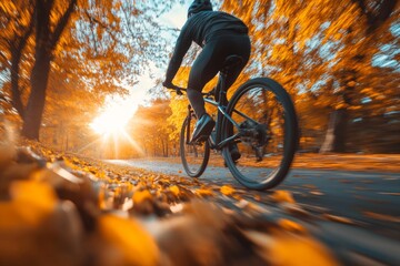 Naklejka premium Cyclist riding through a forest trail covered in autumn leaves