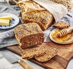 Chleb wypieczony na miejscu z ziarnami na drewnianym blacie w kuchni © Jolaya