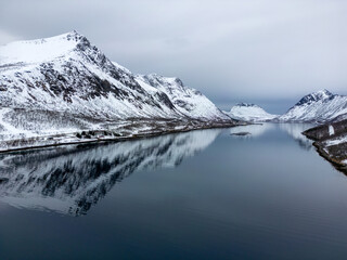 Gryllefjord in Norway, aerial view of mountains and reflecting water surface