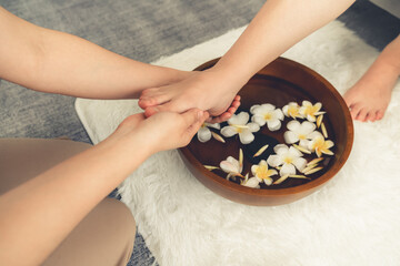 Woman indulges in blissful foot massage at luxurious spa salon while masseur give reflexology therapy in gentle day light ambiance resort or hotel foot spa. Quiescent