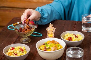 Muslim woman with hand at table eating date iftar Ramadan