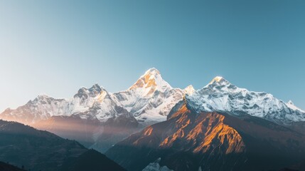 Fototapeta premium a majestic mountain range bathed in golden sunlight, with snow-capped peaks towering against a clear blue sky, white space in the center of the page for text