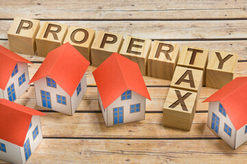 PROPERTY AND REAL ESTATE TAXES concept with home models, cadastral map and General Urban Plan