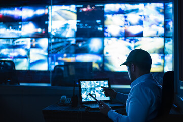 Security guards are monitoring multiple CCTV monitors and reporting on events that occur.