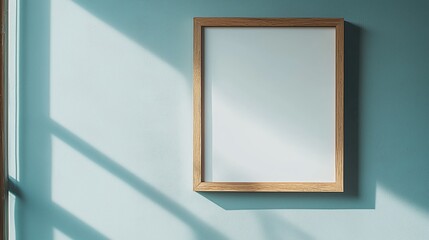 Empty Picture Frame on Blue Wall with Natural Light Shadows