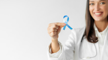 Colorectal Cancer Awareness. Woman doctor holding dark blue ribbon, panorama with free space for design