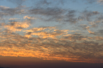 Majestic twilight sky painted with soft clouds and warm hues at dusk over the horizon