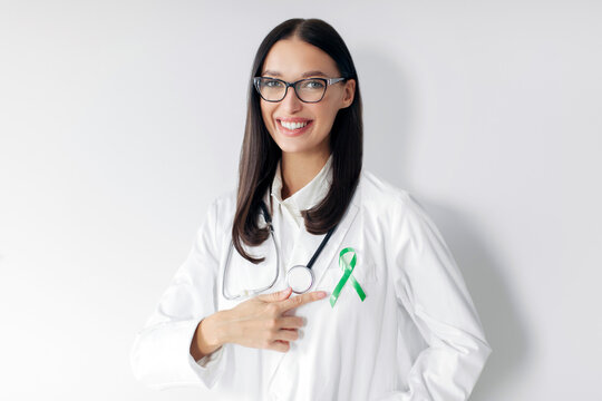 Doctor with green ribbon on her coat for world Lymphoma, Liver, Gallbladders, bile duct, cervical, kidney Cancer Awareness