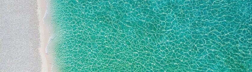 Obraz premium Aerial View of Clear Turquoise Water Lapping Against a Sandy Shoreline on a Sunny Day
