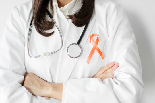 Woman doctor with orange ribbon for Leukemia, Kidney cancer day, world Multiple Sclerosis, CRPS, Self Injury Awareness, closeup - Powered by Adobe