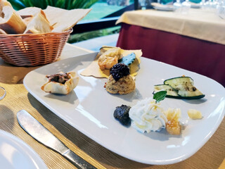 Table with a freshly served dish for lunch. The waiter served the diners their starters.