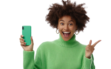 Excited Indian woman in a mint green kurta holding a smartphone horizontally, pointing at the screen with a joyful expression, set against a white background.


