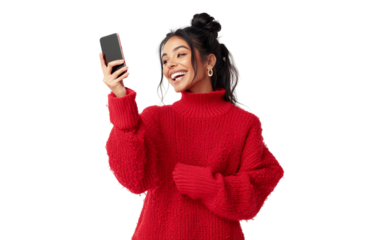 Happy woman in a red sweater holding a smartphone horizontally, pointing at it cheerfully with a bright expression, set against a clean white background.

