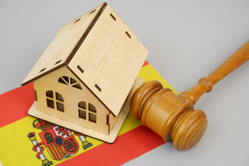 Law and real estate business in Spain. Gavel with wooden house  on Spanish flag.