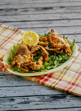 crispy fried soft shell crabs served with fresh lemon on white platter