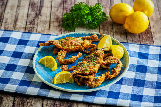 crispy fried soft shell crabs served with fresh lemon on plate platter