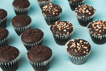 top view and detail Chocolate muffin or cupcake with egg and cake ingredients on blue background. Home baking concept
