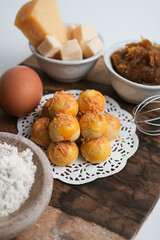 Kue nastar or pineapple tart. indonesian eid snack (kue lebaran). on a wooden plate with ingredients. bright mood style. perfect for recipe, article, catalogue, or any commercial purposes.