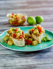 grilled shark steaks topped with a chunky pineapple salsa served on a green plate