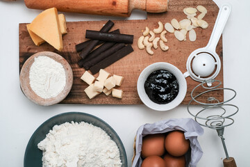 Baking ingredients for chocolate cake muffins or cookies lying ready on wooden kitchen tray. Mise en place, white background, measured ingredients.