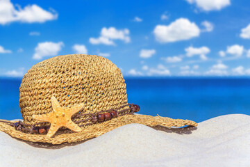 Close-up view of a sun hat on a sandy beach by the sea, selective focus. Beach holiday concept,...