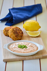 spicy tartar sauce served with crab cakes on a cutting board