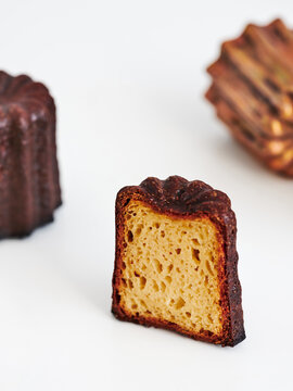 Delicately shaped caneles de Bordeaux showcase their dark, caramelized crust and soft, flavorful interior. Perfect centerpiece for a dessert spread or bakery display