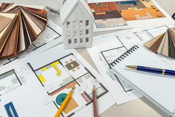 On the table, there is a detailed floor plan of a house showcasing its layout and design