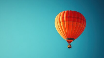 Obraz premium Orange Hot Air Balloon Soaring High in a Clear Blue Sky