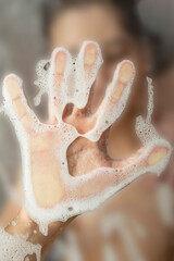 child hand print with white foam on shower glass wall, abstract backdrop