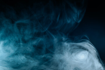 Abstract swirling blue smoke on a dark background, creating a mysterious and ethereal atmosphere. Perfect for artistic, moody, or creative designs.